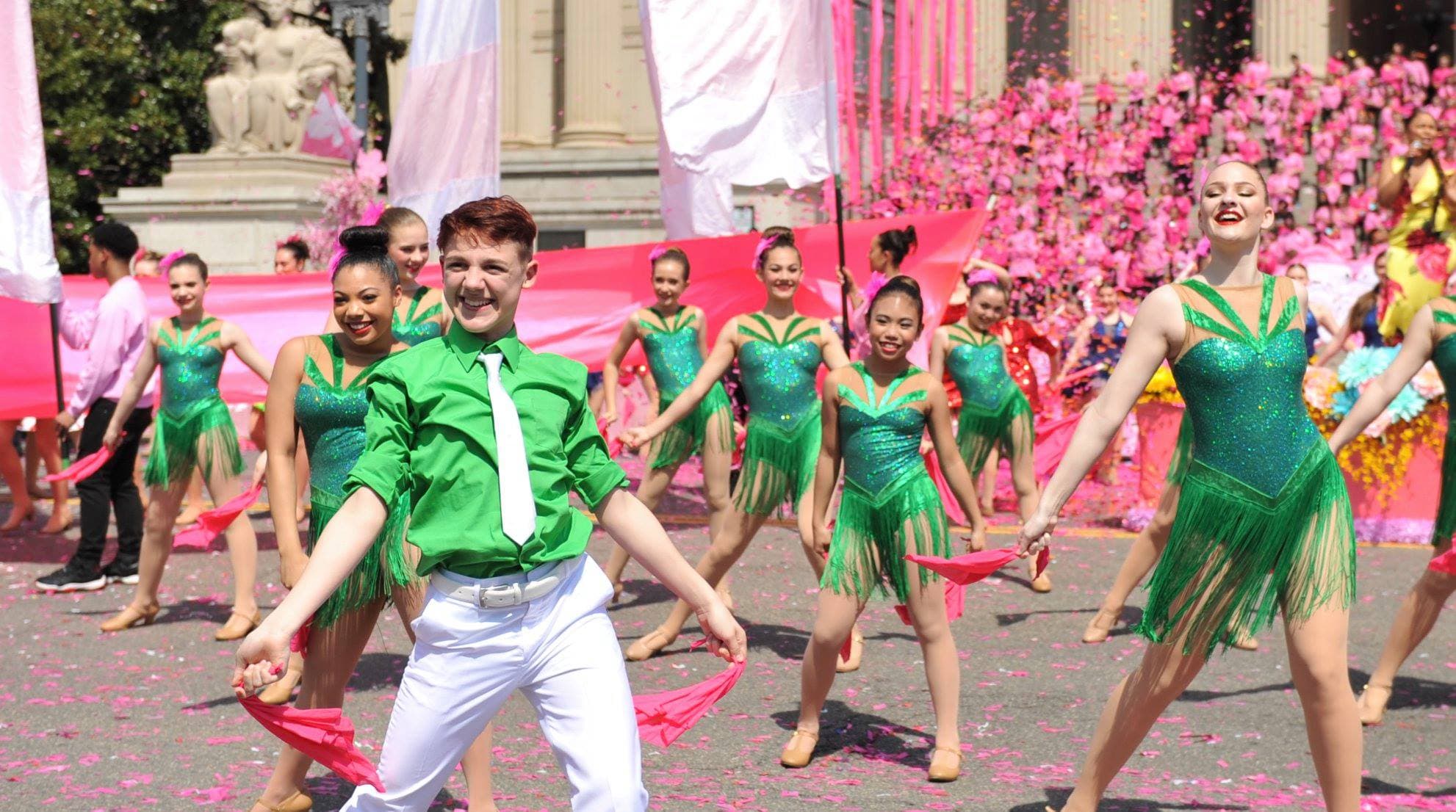 Melina's Dance Company performers in green sequin costumes dancing in a parade